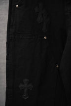 Black pants with cross applique and silver metal rivet pocket details
