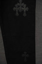 Black pants with stacked cross embroidery on the leg