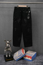 Black cropped cargo pants with cross patches and snap front, hanging on hanger
