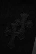 Black pants with large embroidered cross patch on leg