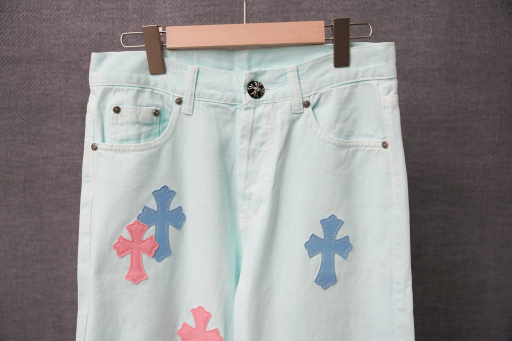 Light blue denim pants front view with colorful cross patches on legs