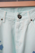 Light blue denim pants waistband close-up with black button and belt loops