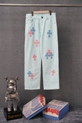 Light blue denim pants with colorful cross patches, button and zipper front.