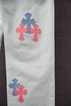 Light blue pants with blue and pink cross patches on the side leg