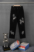 Black jean-style pants with silver cross appliqué, straight leg and button waist