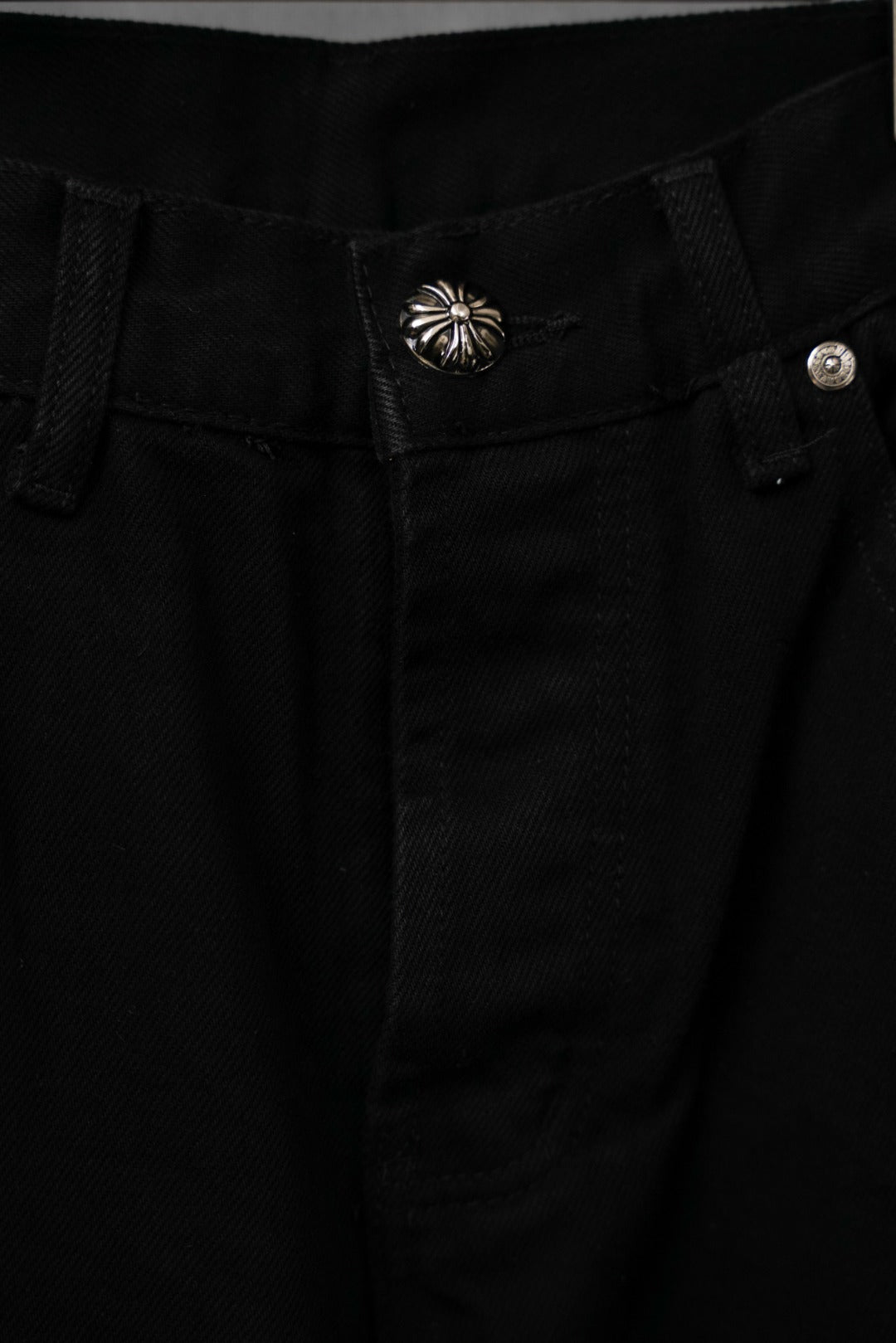 Black pants waistband with decorative metallic button