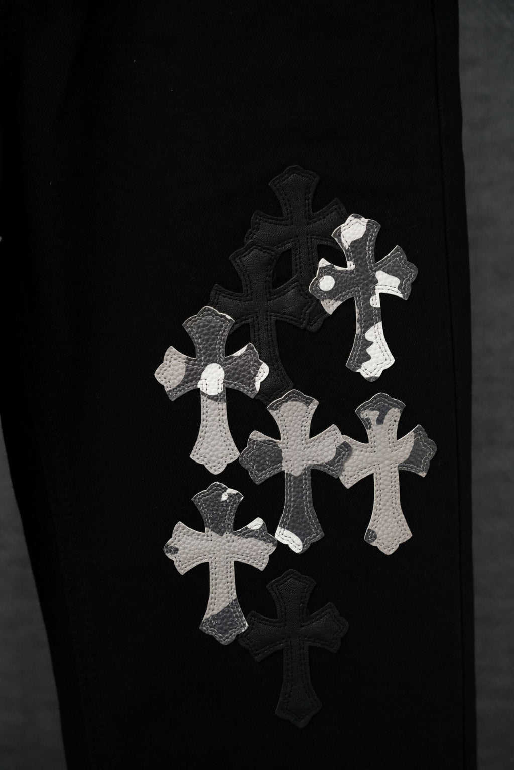 Black pants leg with small white cross appliqué patches