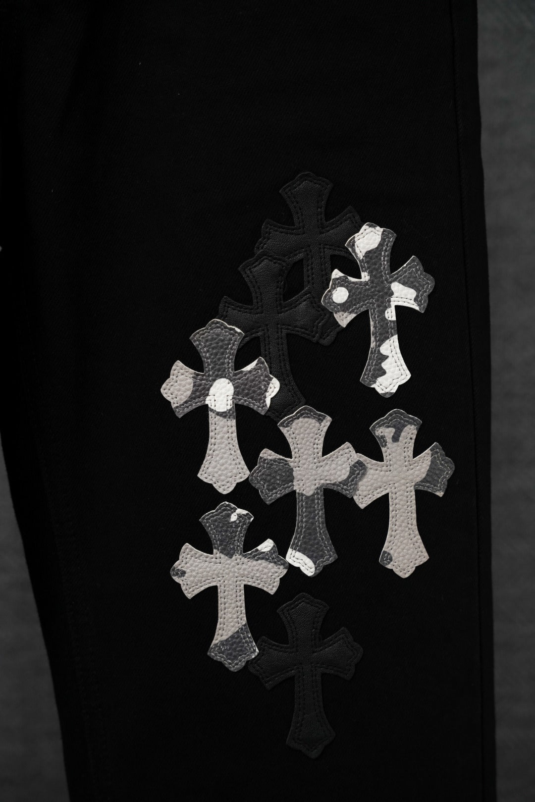 Black pants leg with small white cross appliqué patches