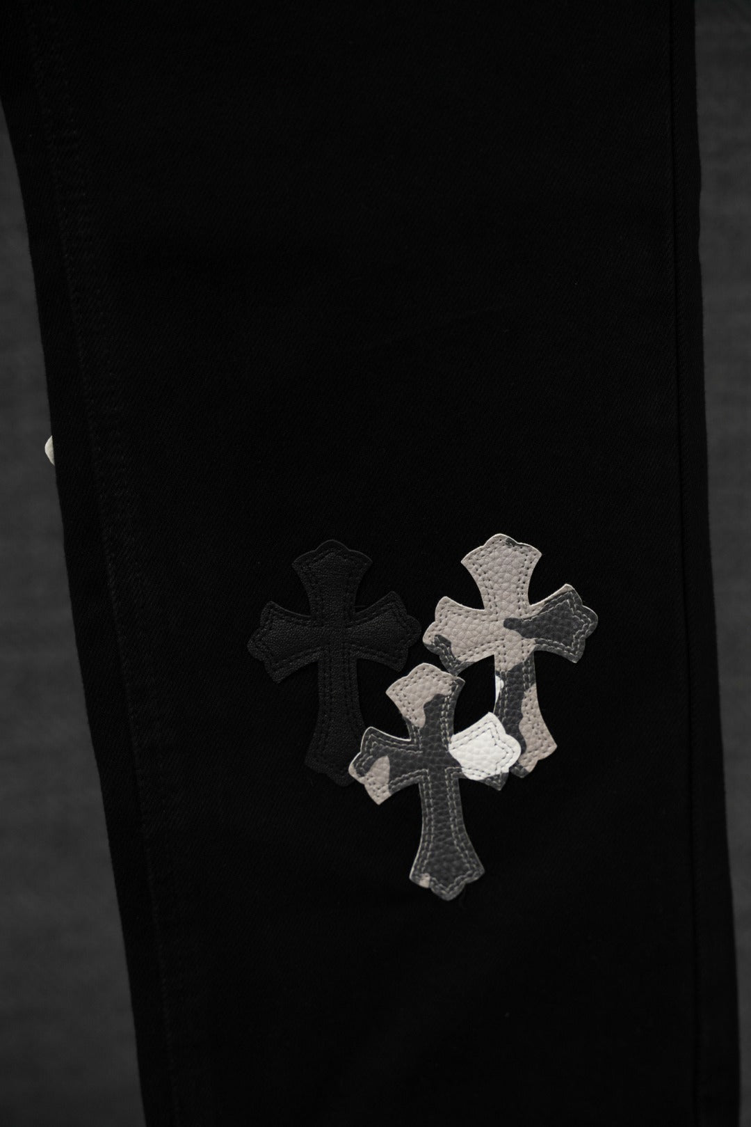 Black pants with cross appliqué patches on the front leg