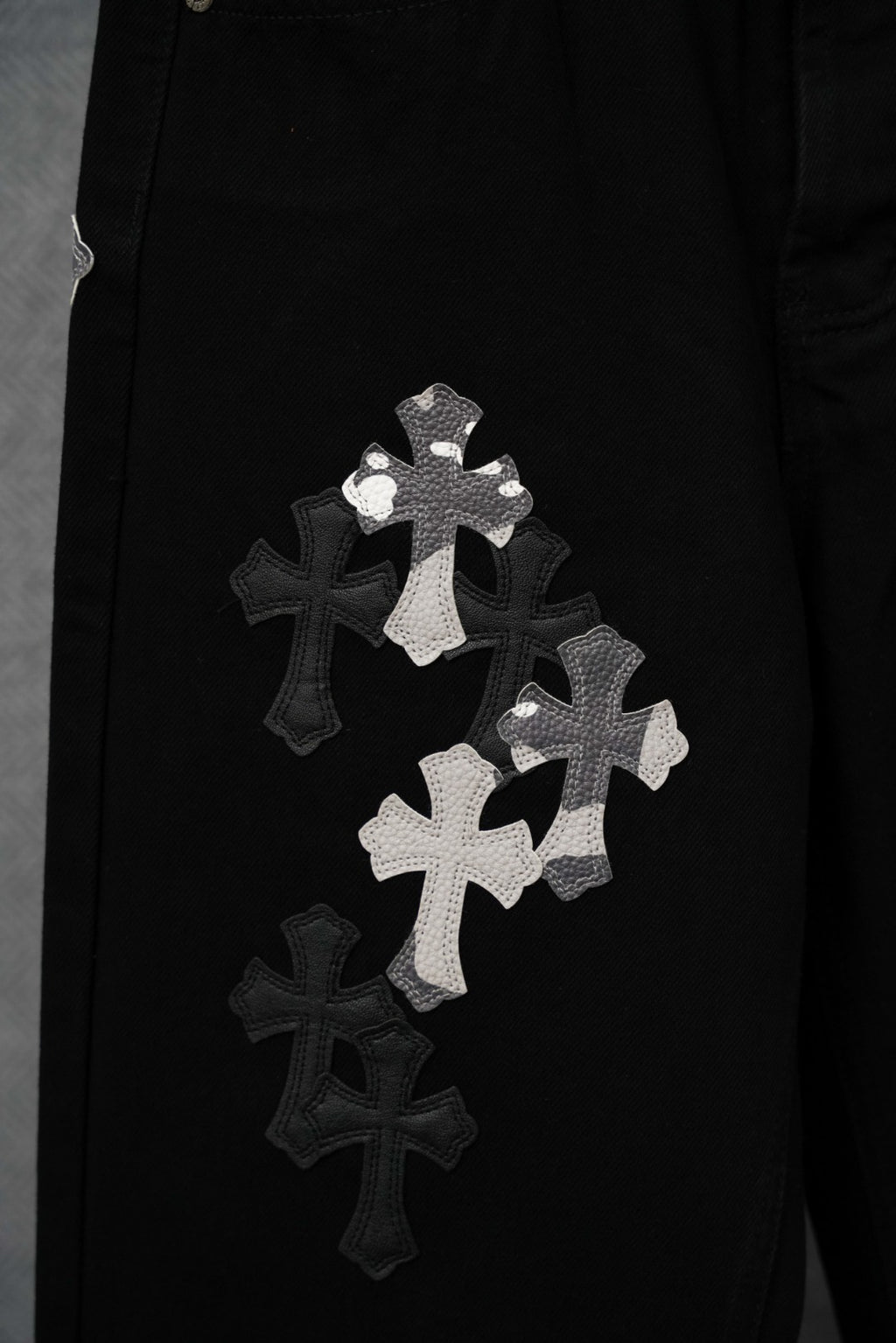 Black pants with cross appliqué patches and white lettering detail