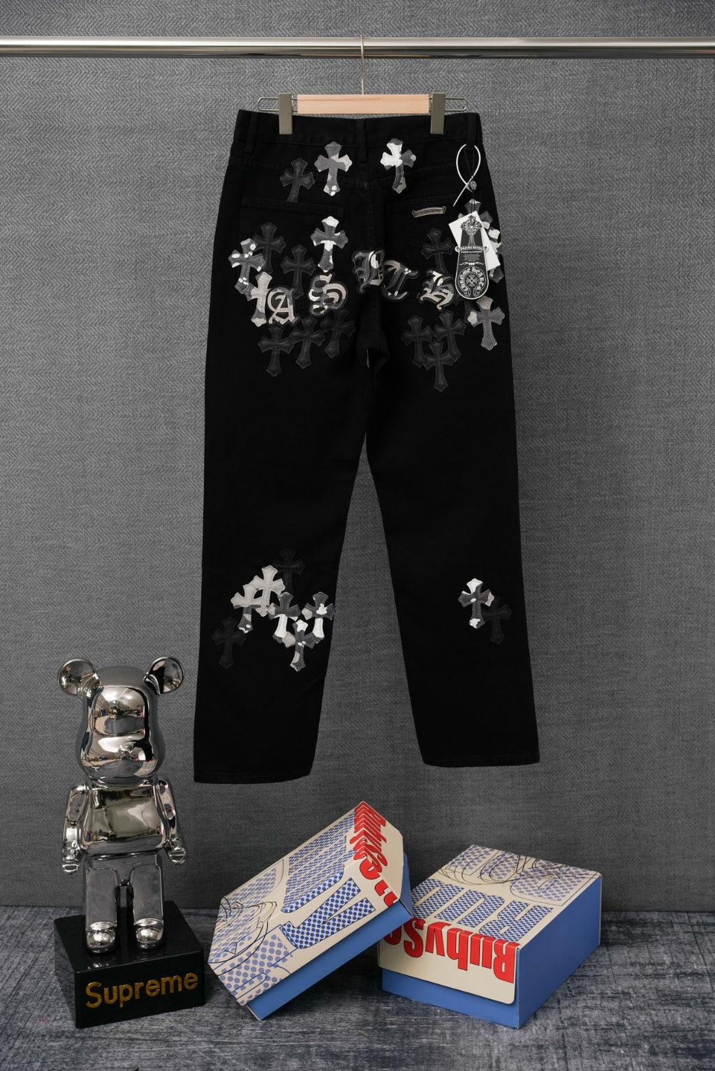 Black pants with scattered white cross appliqué patches, front view