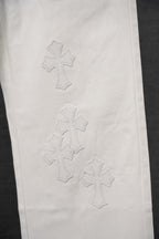 White pants with stitched cross patterns on the leg