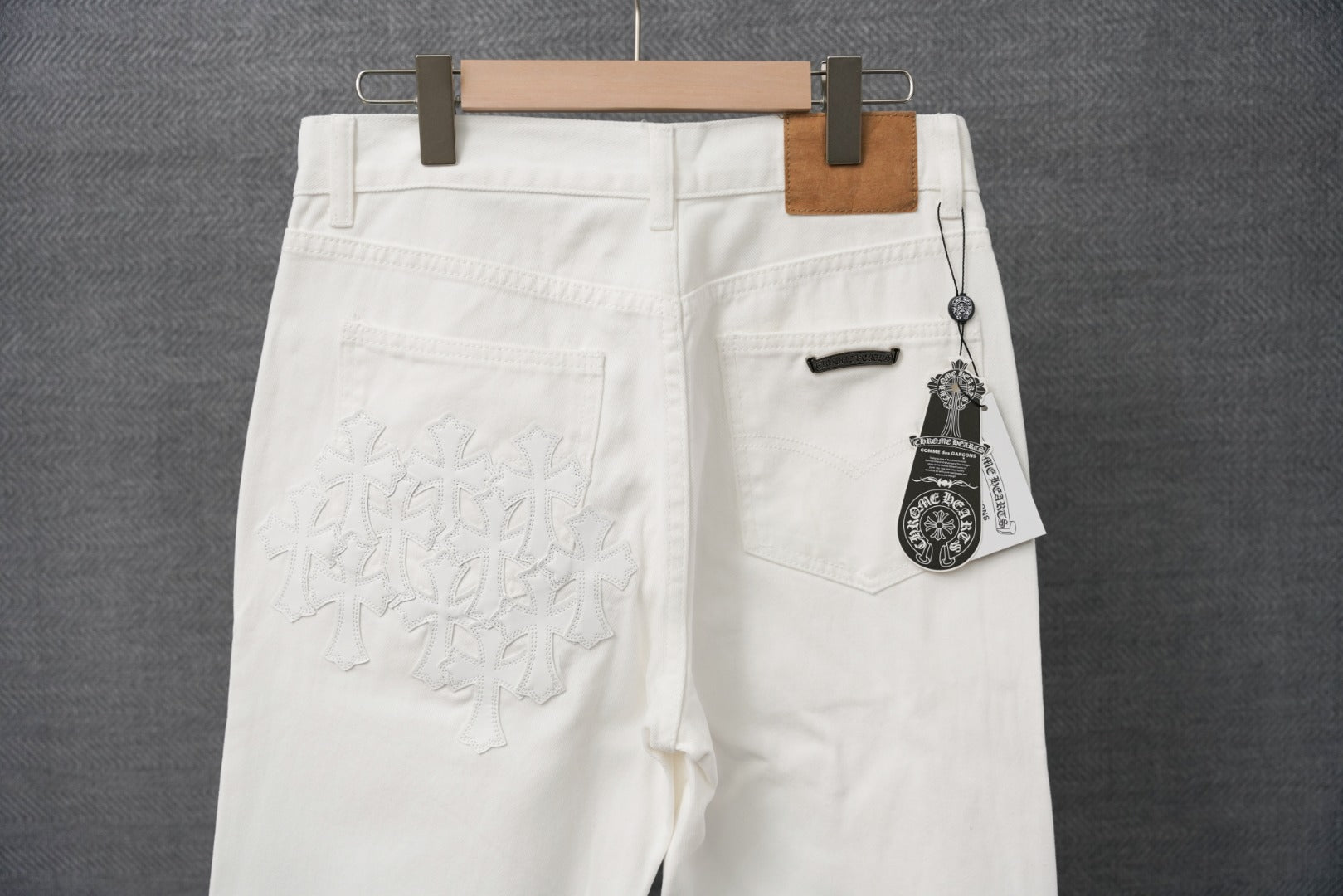 White pants back view with stitched logo detail and buttoned pocket