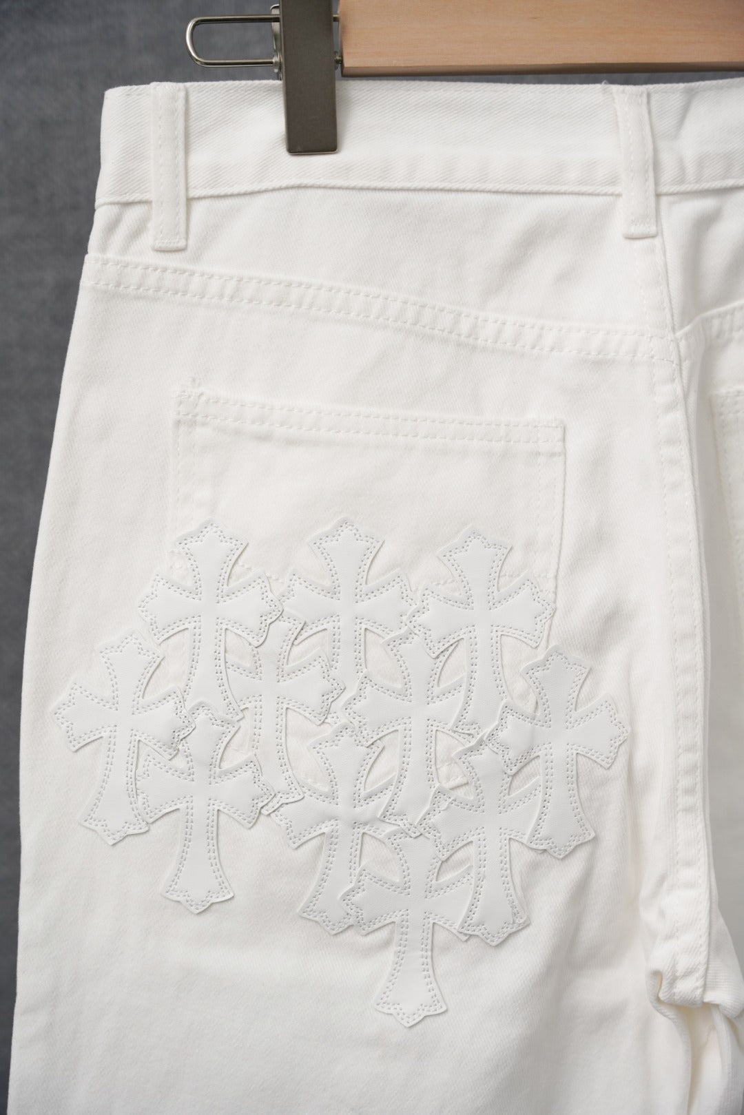 White pants with embroidered front panel and stitched pockets