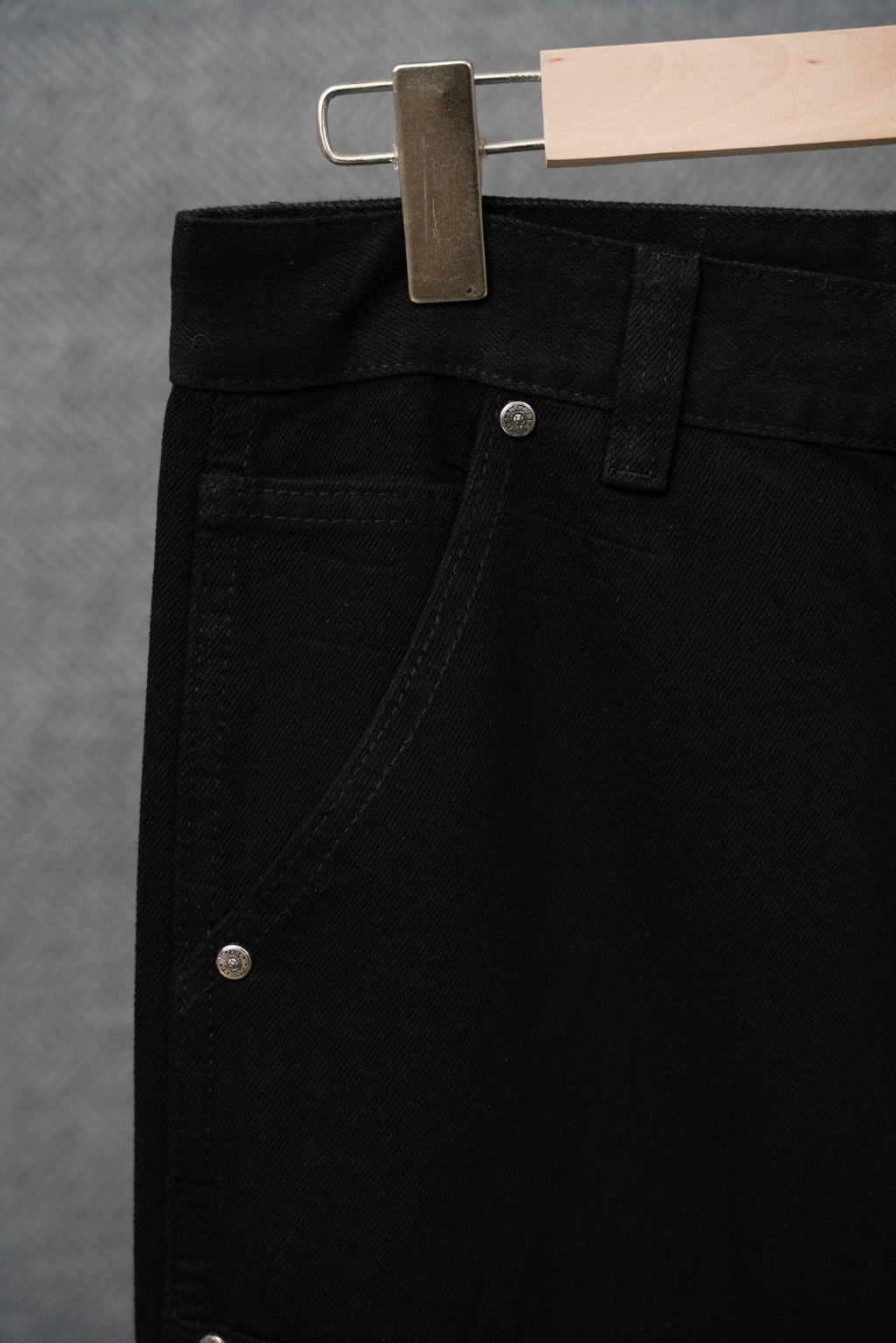 Black cargo pants close-up of waistband, belt loops, and front button