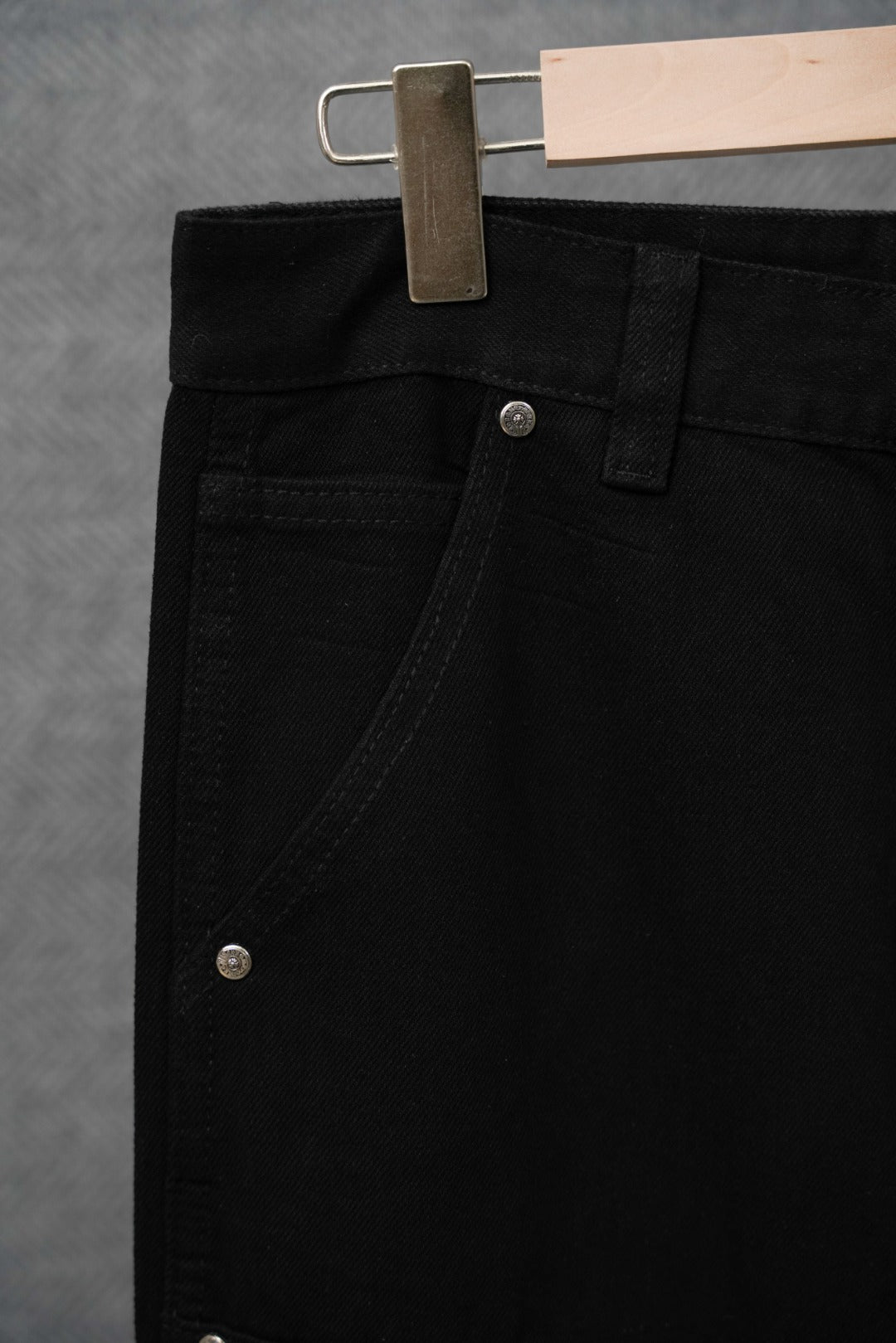 Black pants close-up of waistband with button and belt loops