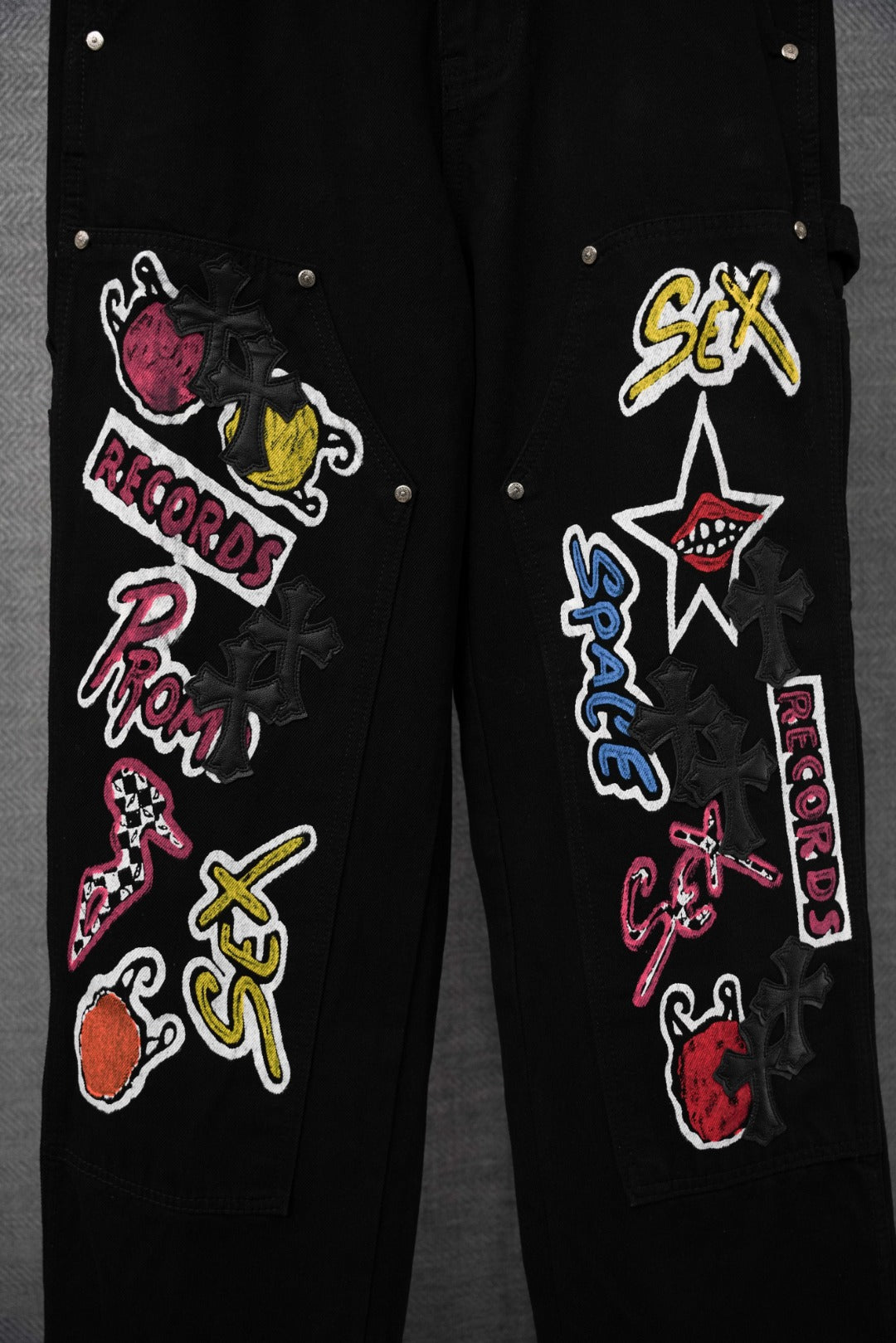 Black cargo pants close-up of side leg with colorful embroidered graphic patches