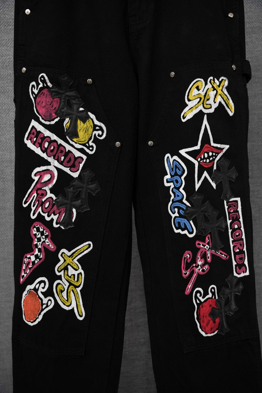 Black pants side view with colorful embroidered patches and studs