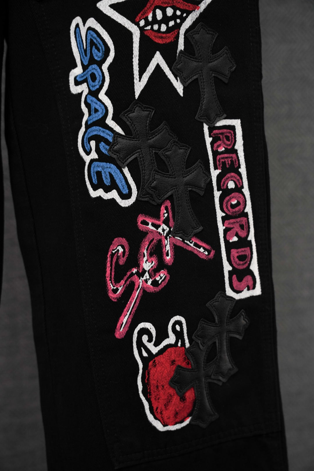 Black cargo pants close-up of leg patch with stacked text and star graphic