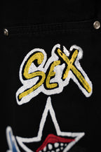 Black cargo pants close-up of embroidered logo-style text and small star patch