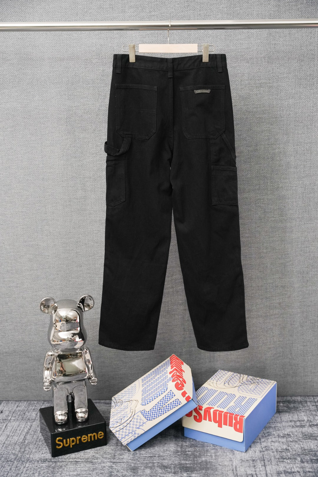 Black cargo pants with multiple embroidered patches, full-length view