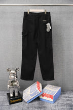 Black cargo pants with side pockets and a small tag, front view