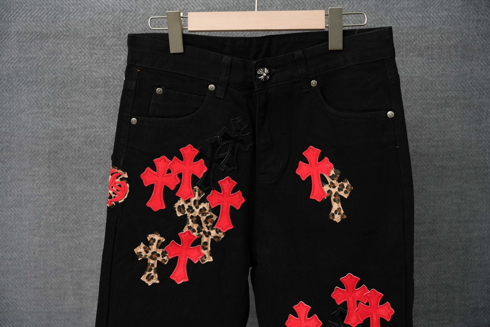 Black Chrome pants with red and leopard cross appliques, close-up