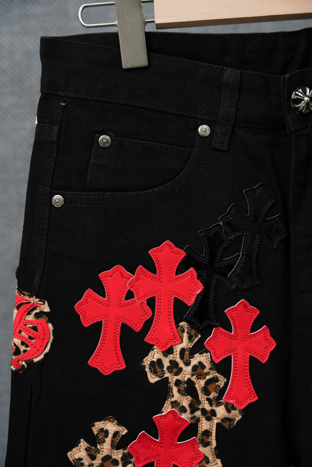 Black pants pocket area with red cross and leopard pattern patches.