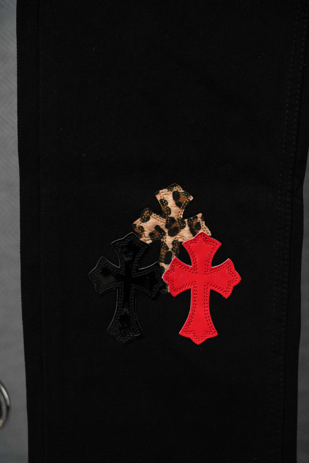 Black Chrome pants with leopard-print cross and red applique detail