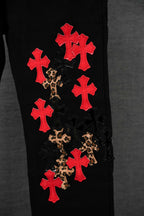 Black pants leg with red cross patches and leopard scatter detail.