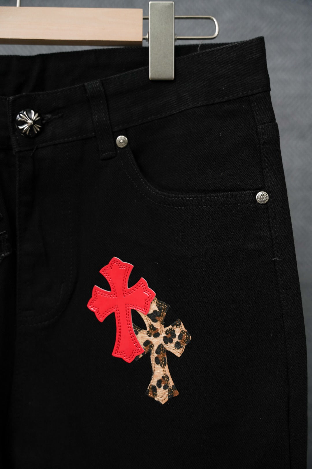 Black Chrome pants pocket area with red cross and leopard-print appliques