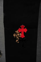 Black pants with red cross patch and leopard-print detail near leg