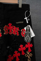 Black pants with red cross patches, leopard trim, and decorative patches