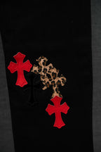 Black pants with red cross patches and leopard-print accents
