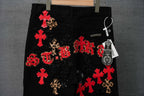 Black pants with red cross patches, leopard motifs, and ornate lettering