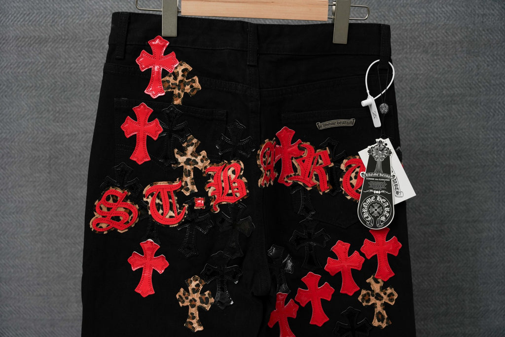 Black pants with multiple red crosses, leopard patches, and red embroidered letters