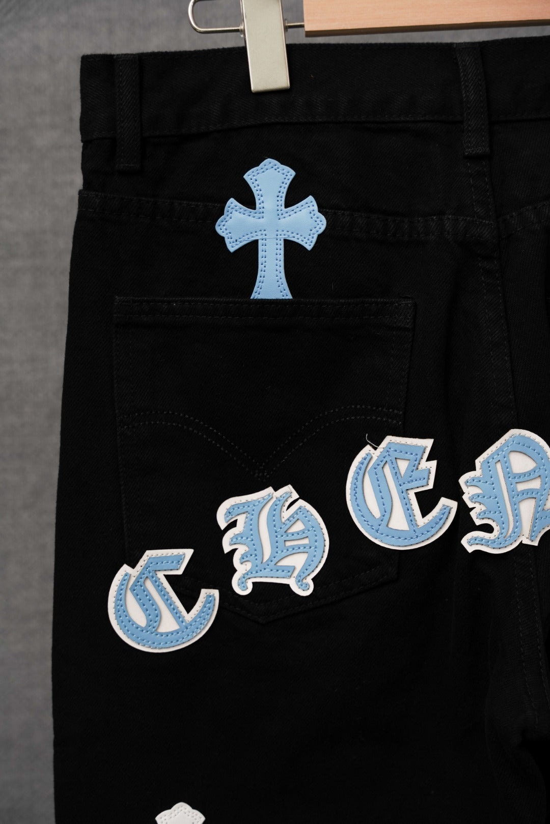 Black pants with light blue and white cross patches on thigh and pocket