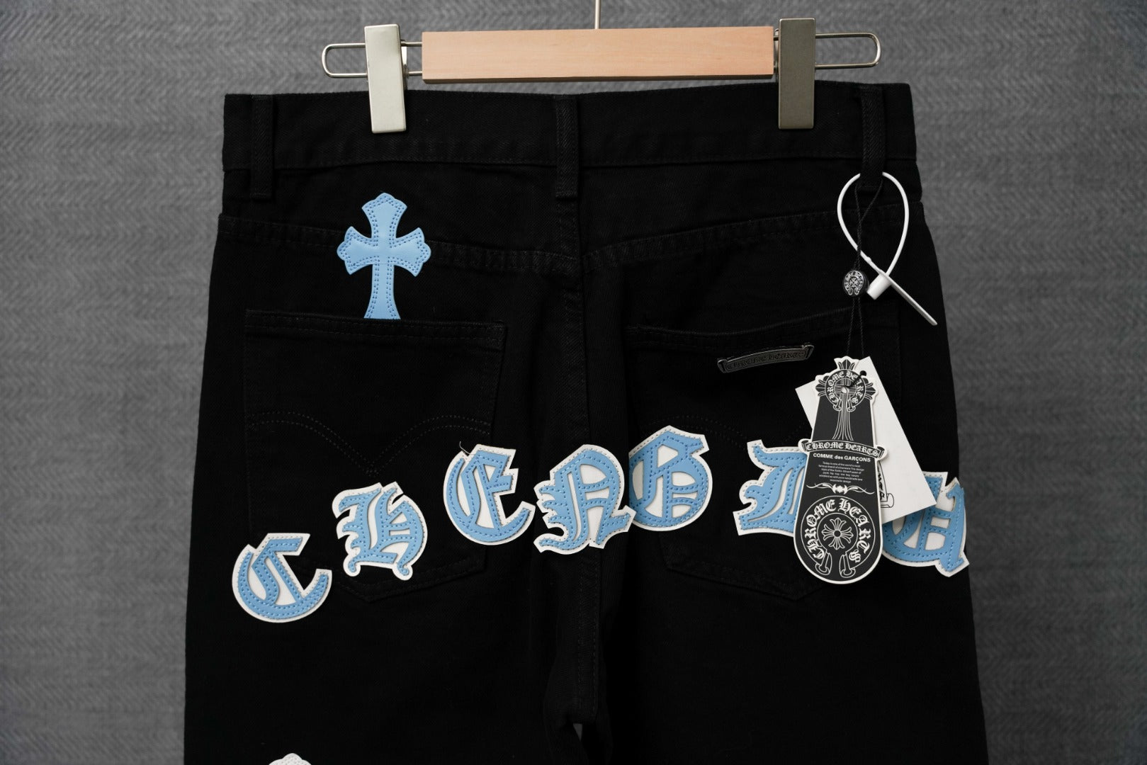 Chrome pants, black with blue cross emblem graphics on front waistband area