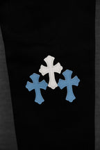 Black pants with multiple light blue and white cross patches on front