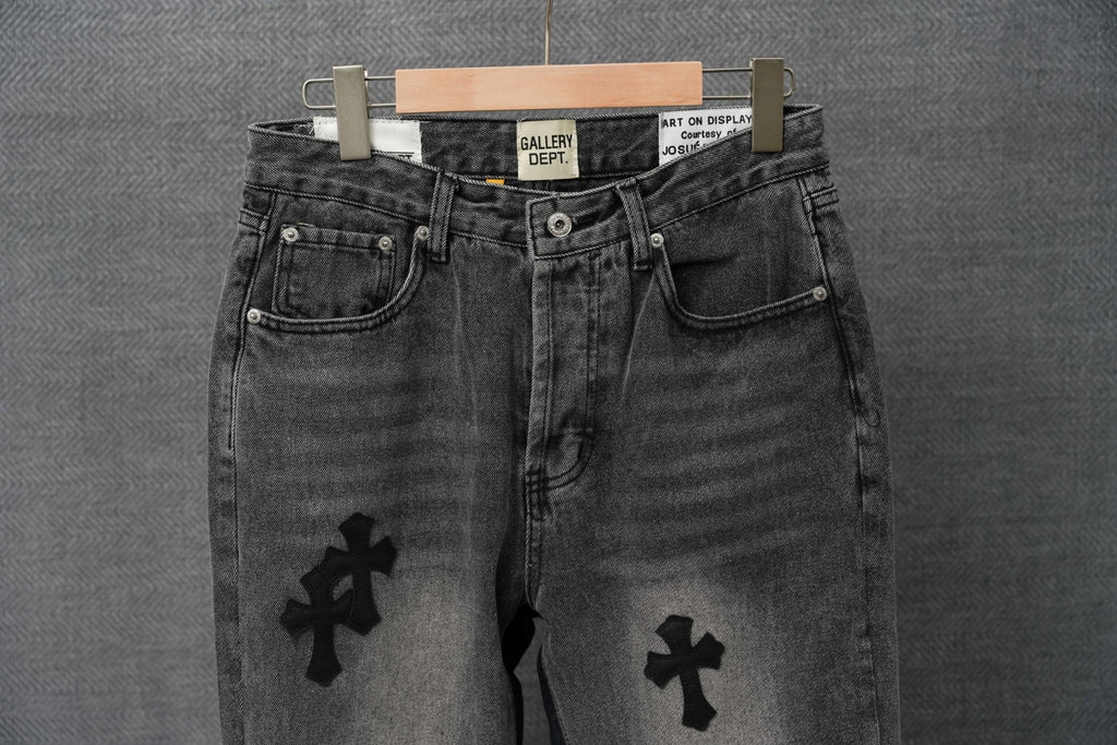 Dark denim pants with button fly and cross patches on the legs