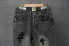 Dark denim pants with button fly and cross patches on the legs