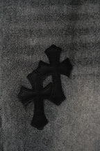 Close-up of cross emblem print on dark denim fabric