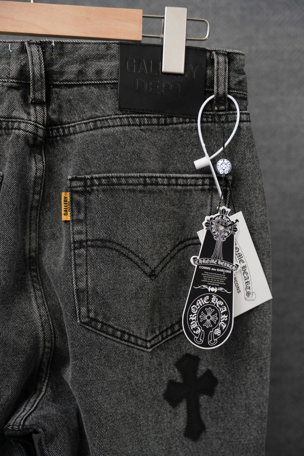 Dark denim pants with heart back pocket and small cross patch, hanging tag