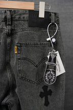 Dark denim pants with heart back pocket and small cross patch, hanging tag