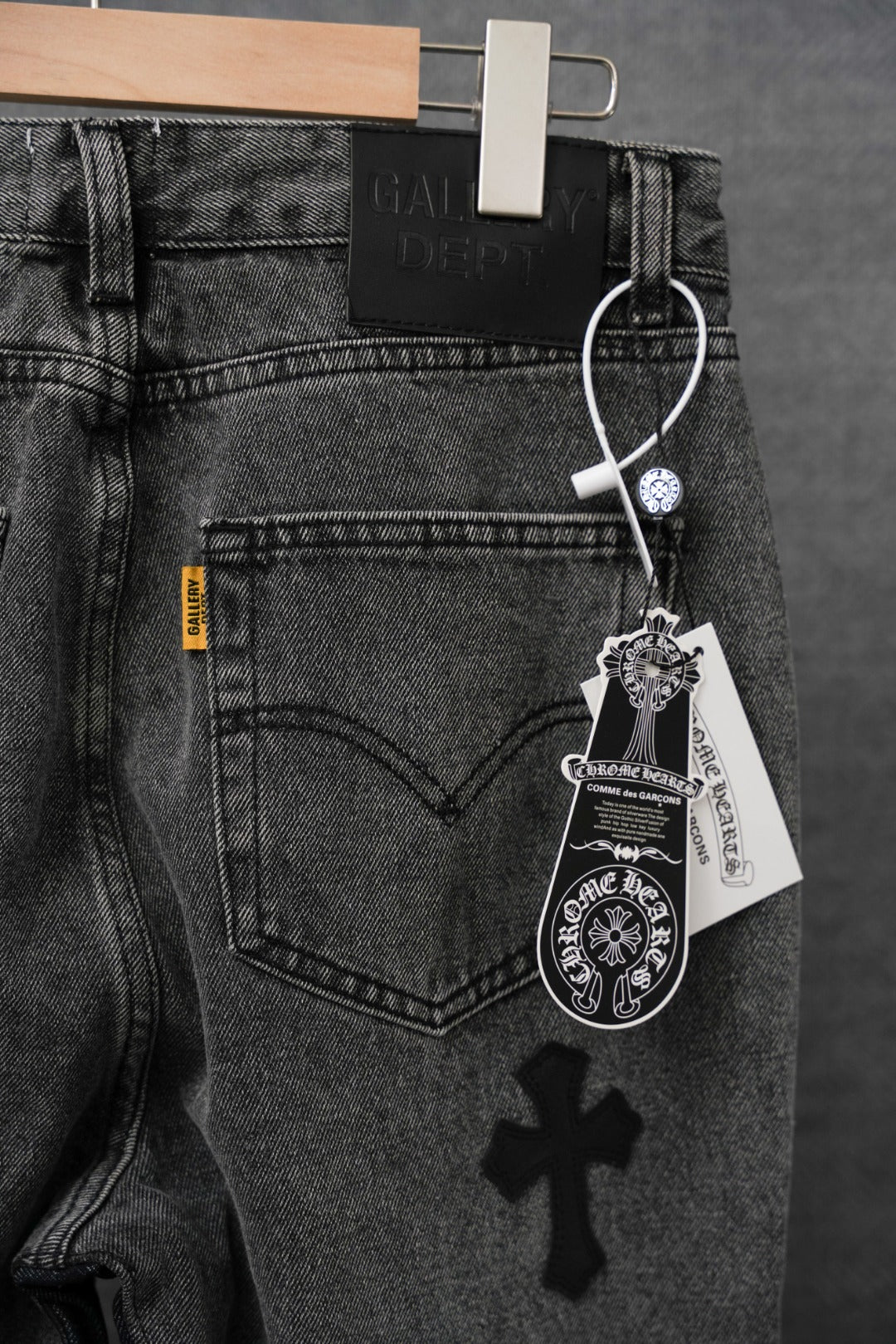 Dark denim pants with heart back pocket and small cross patch, hanging tag