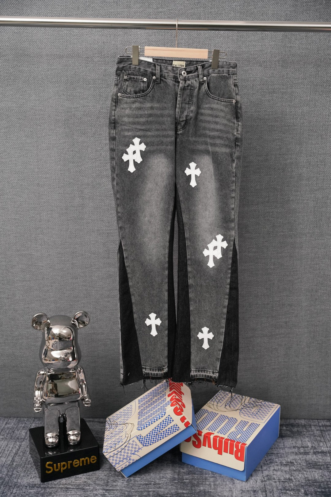 Black denim pants with white cross patches and button fly