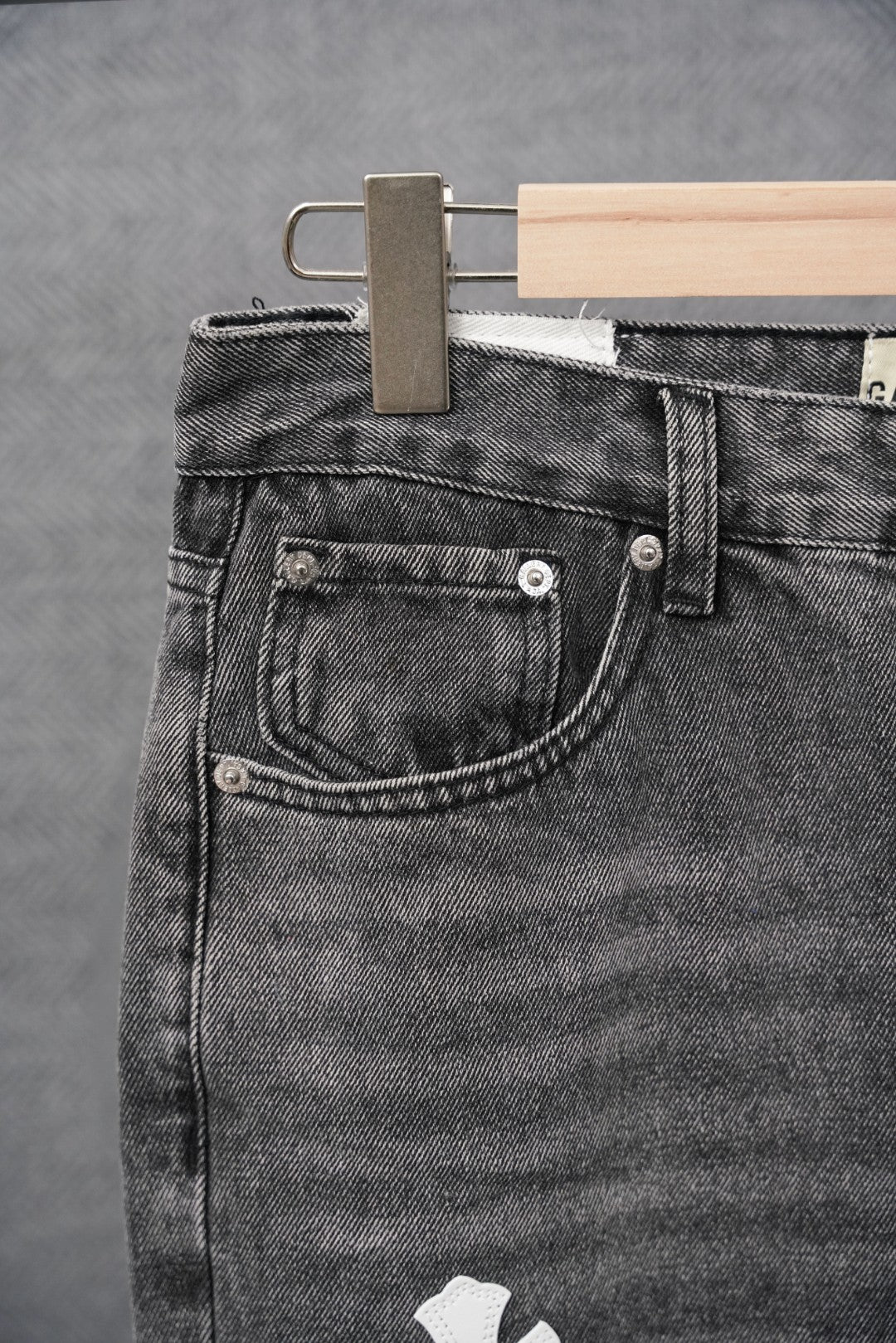 Black denim jeans pocket with metal buttons and stitched waistband yoke