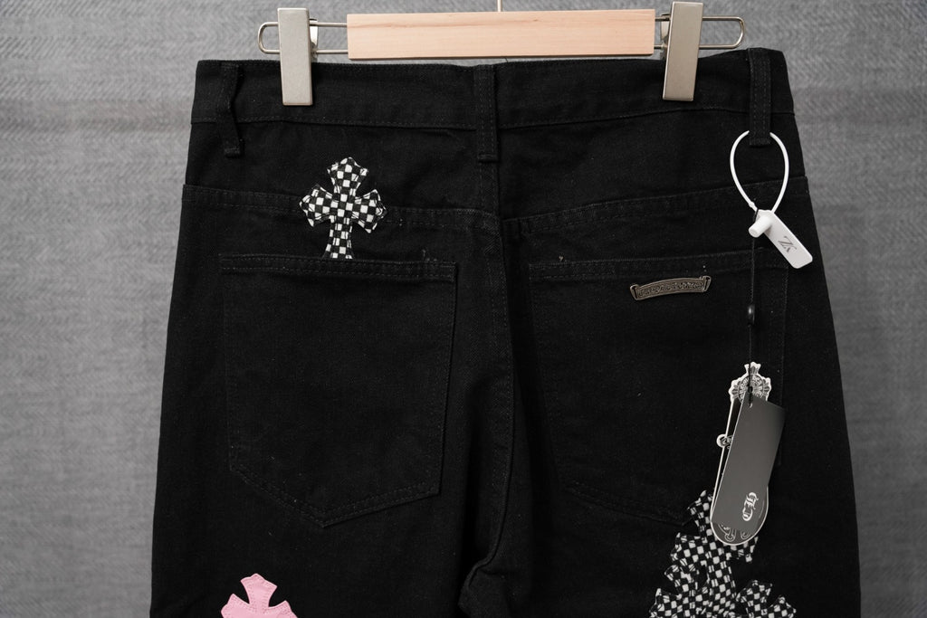 Black pants with belt loops, front pockets, checkered patch details, and hang tag