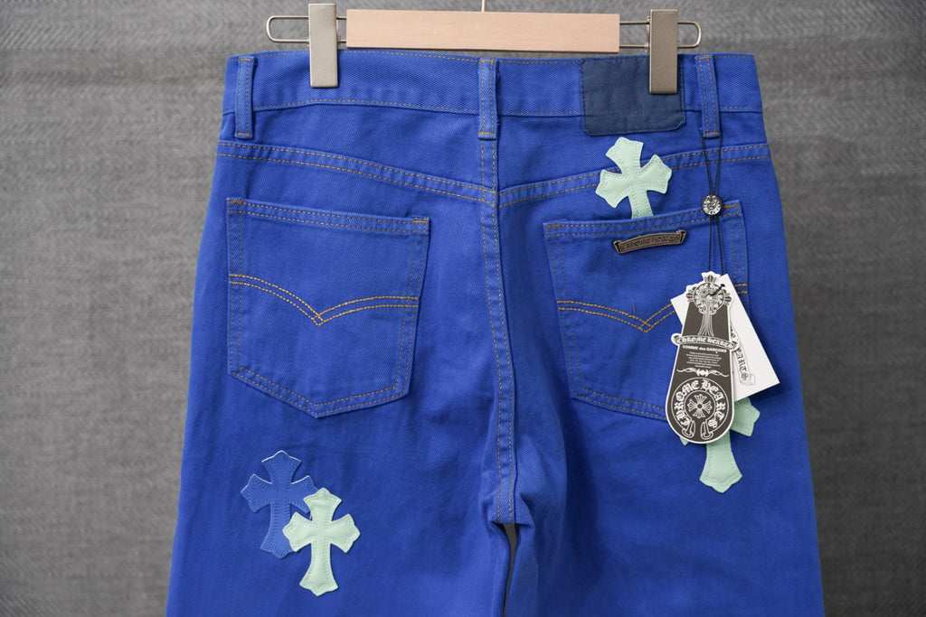 Chrome pants in blue with cross applique patches, front pockets, and belt loops
