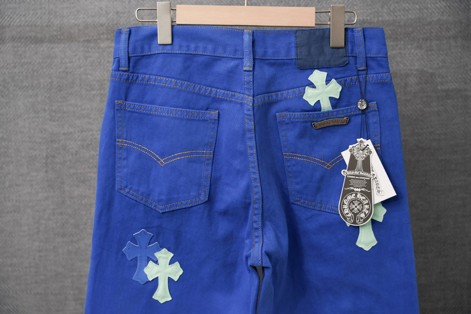 Blue pants with cross-shaped patches at front, zip fly and belt loops